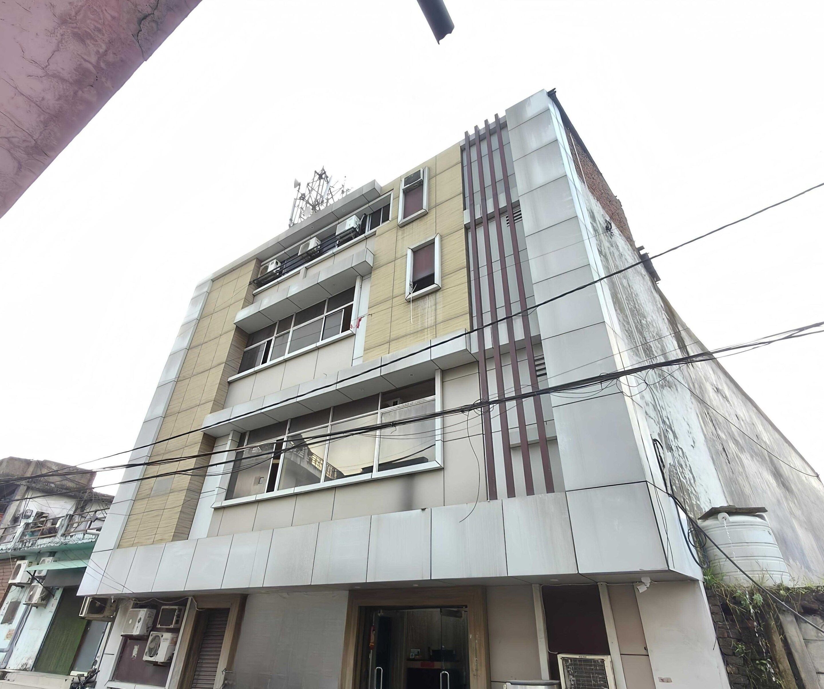 A multi-story building with a flat facade, multiple windows, and visible air conditioning units.