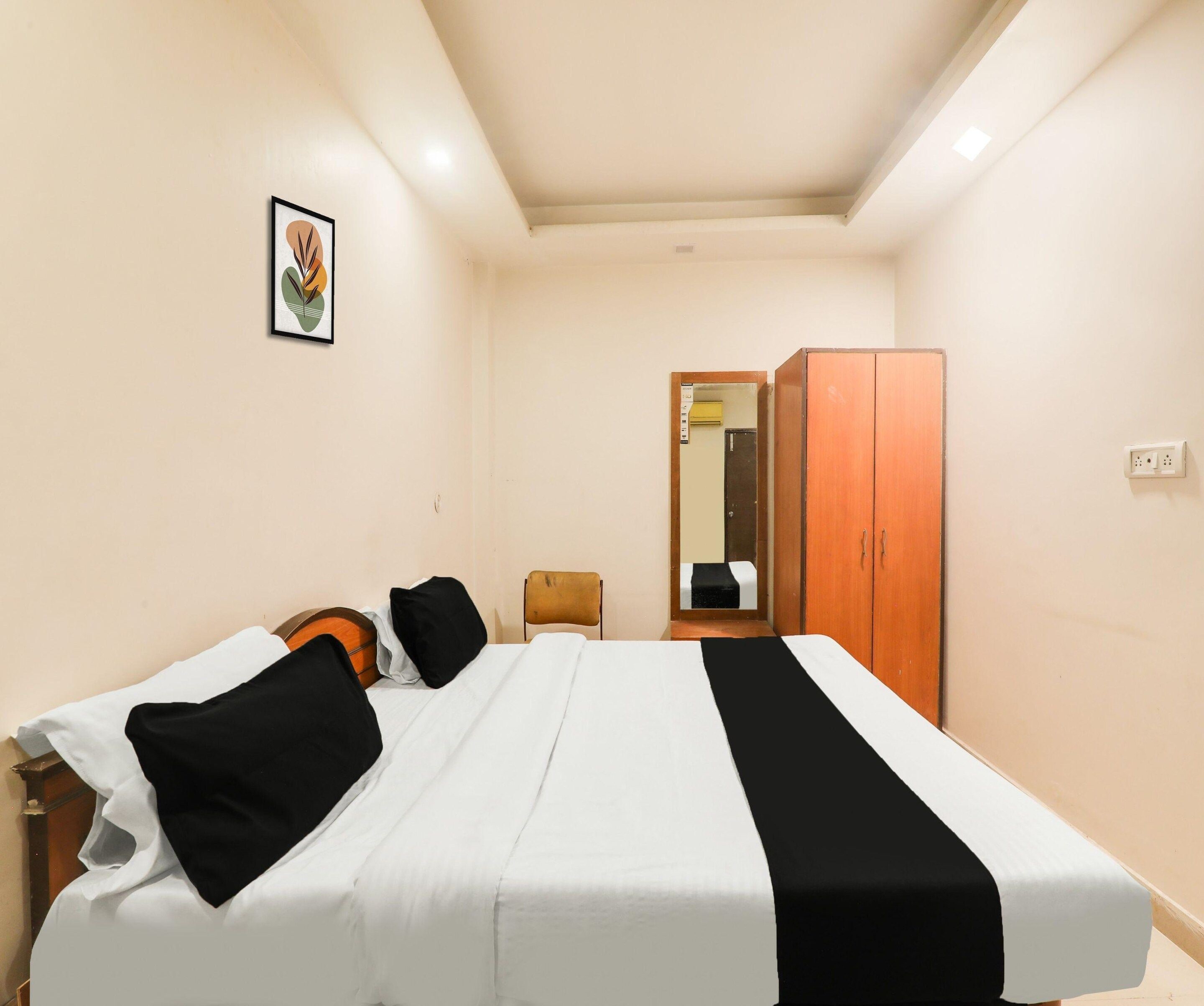 Un dormitorio con cama, armario, una silla y un cuadro en la pared.
