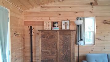 Un intérieur en bois comprenant un meuble, un porte-manteau, une lampe et un canapé.