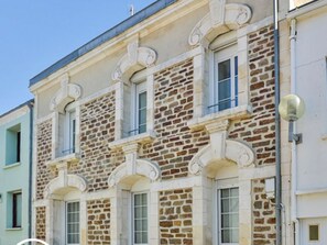Ein mehrstöckiges Gebäude mit einer Stein-Fassade und zahlreichen Fenstern.