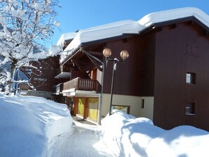 Ein schneebedecktes Gebäude mit einem Balkon und einem Schild, auf dem 'Val Blanc' steht.