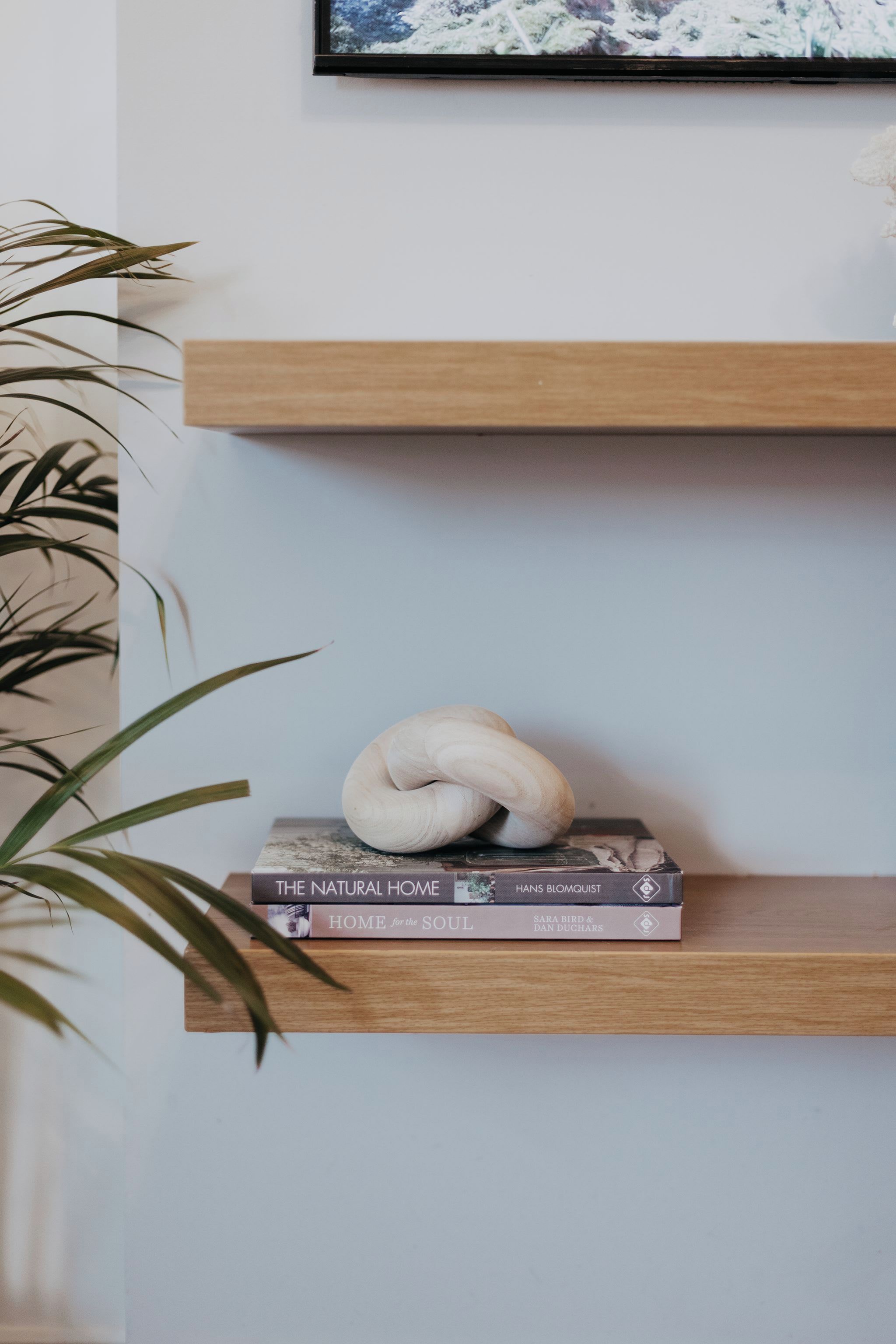 A shelf with a book titled 'The Natural Home' and a decorative item.