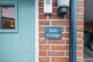 A brick wall with a sign reading 'Halo Cottage.' - Halo Cottage by Navie Stays (Poole)