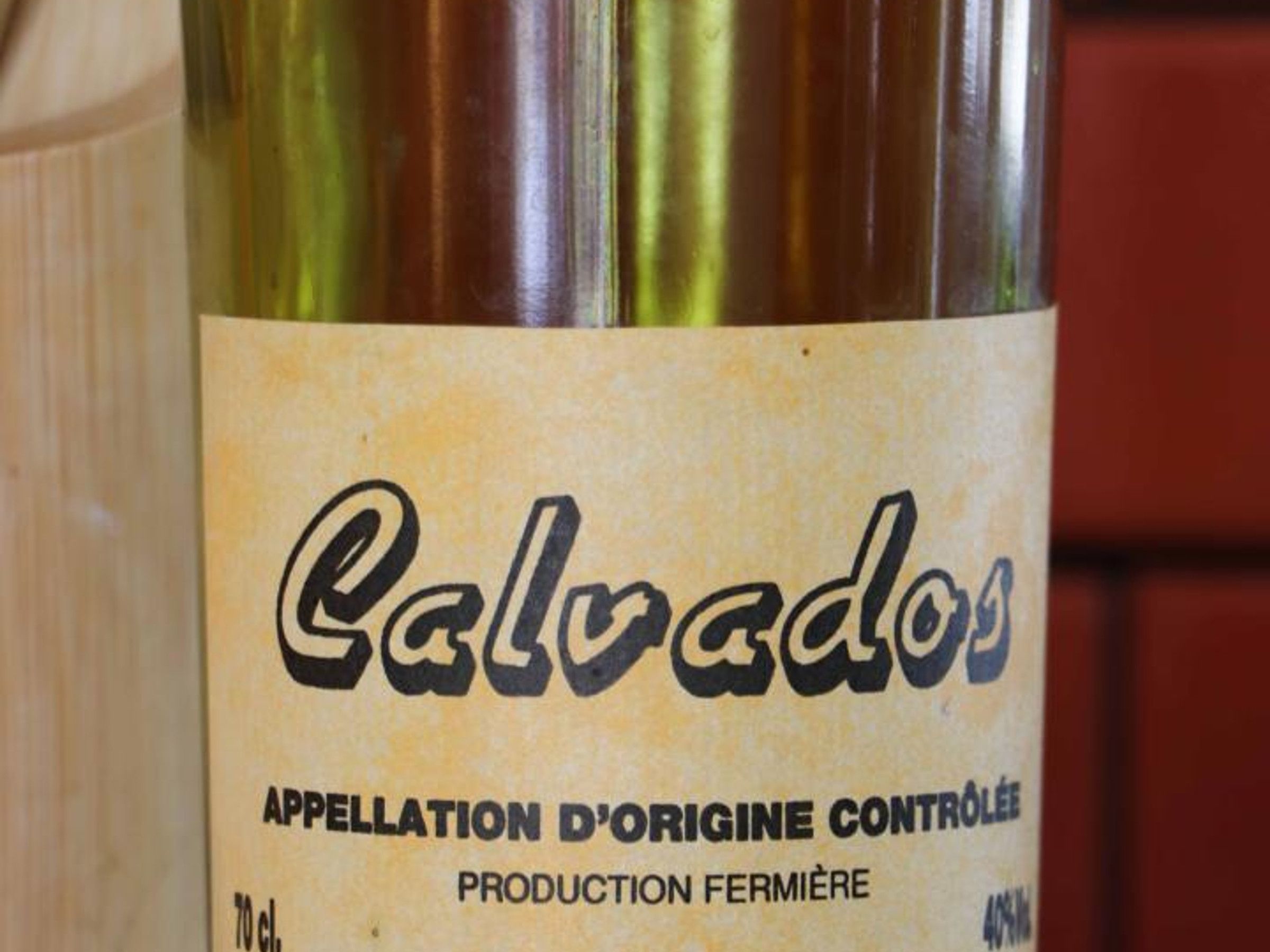 Een etikette van een wijnfles met de naam 'Calvados' en de tekst 'Appellation d'Origine Contrôlée', wat aangeeft dat het een wijn betreft met beschermde oorsprongsbenaming.