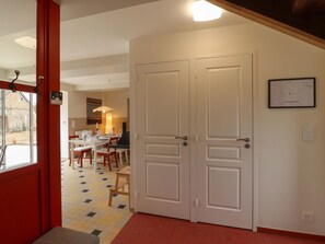 Une chambre d’hôtel avec un coin repas, un piano et une carte accrochée au mur.