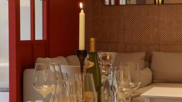A dining table with wine glasses, a bottle, and a lit candle.