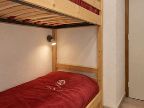A bunk bed with a red blanket and a wall-mounted light fixture. - Quiet studio with parking - 4 guests (Le Grand-Bornand)