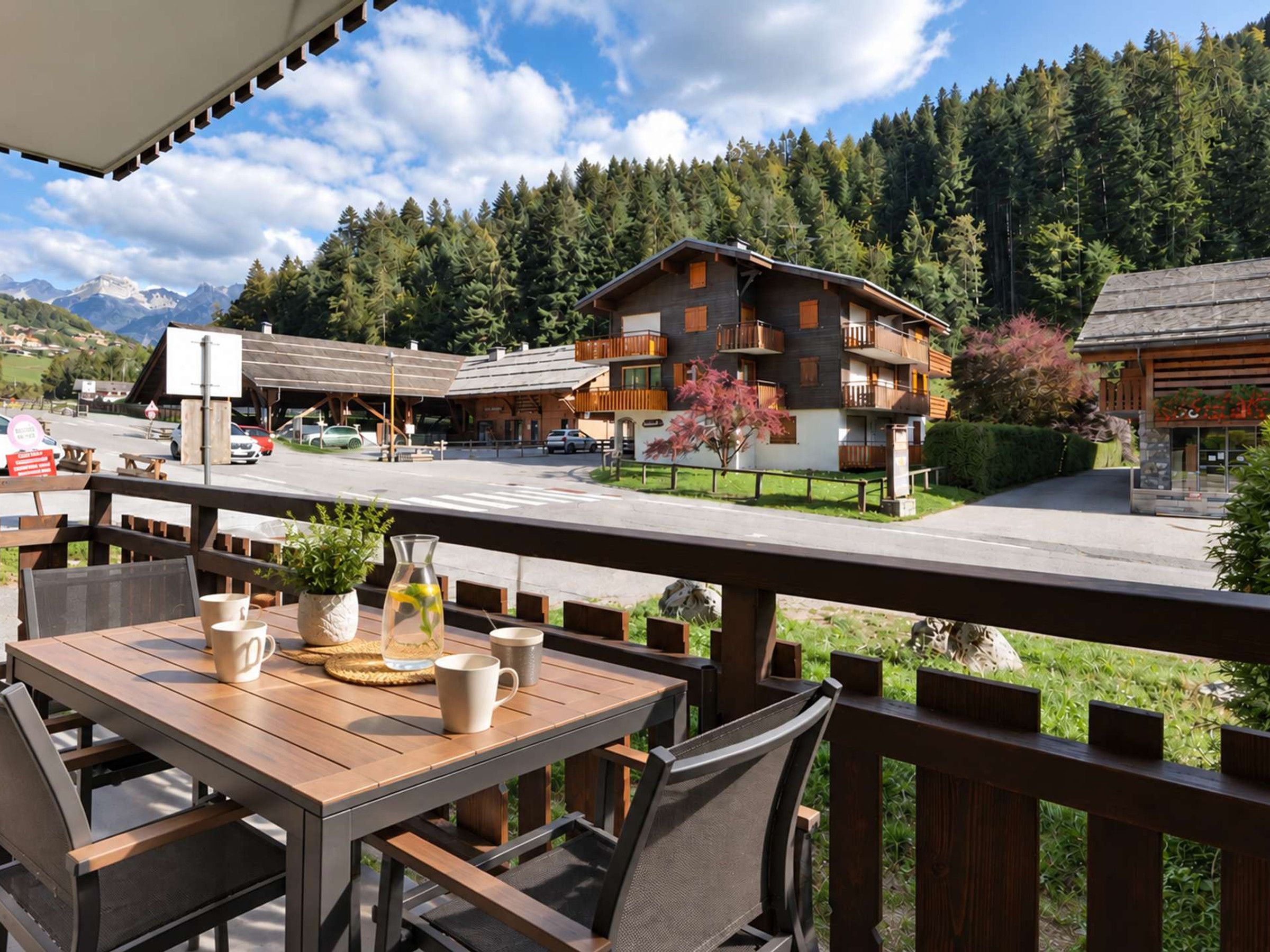 An outdoor seating area with wooden tables and chairs, overlooking a mountain landscape with a building in the background.