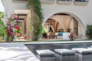 A pool area with a seating area and a covered patio. - Beautiful beachfront villa with Spanish architecture (Savegre)