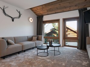 Ein modernes Wohnzimmer mit einer Couch, zwei Couchtischen und einem Kamin.