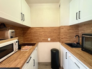 A compact kitchen with white cabinets, a microwave, a toaster, a sink, and a trash bin. - Apartment mountain view - 4 guests (Plagne Bellecôte)
