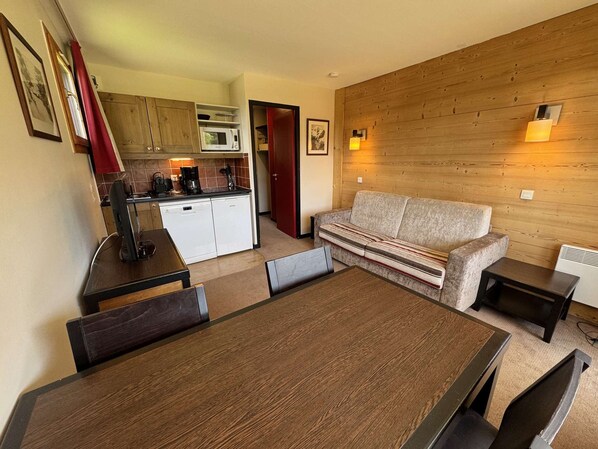 A compact living space with a kitchenette, a sofa, a dining table, and a small side table. - Apartment mountain view in Belle Plagne - 4 guests (Belle Plagne)