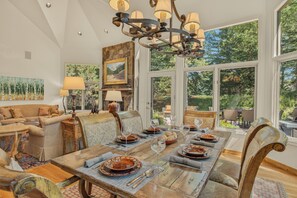 A dining area with a large wooden table set for a meal, surrounded by comfortable seating. - Mountain Retreat + Pet Friendly + Game Room + Community Hot Tub | Wild Iris Lodg (Edwards)