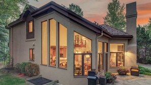 Ein modernes Haus mit großen Fenstern, einem Balkon und einem Schornstein.