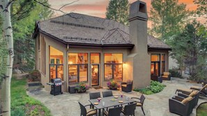 A house with a large patio, outdoor seating, and a chimney. - Mountain Retreat + Pet Friendly + Game Room + Community Hot Tub | Wild Iris Lodg (Edwards)