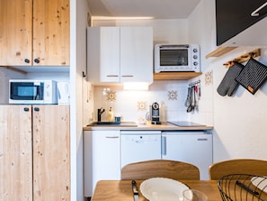 Eine kleine Küche mit Mikrowelle, Toaster und Geschirrspüler.