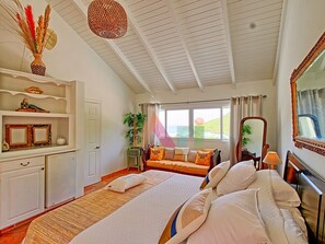 A bedroom with a bed, bedside table, and a window with a view. - Villa panoramic sea view - 12 guests (Saint-Martin)