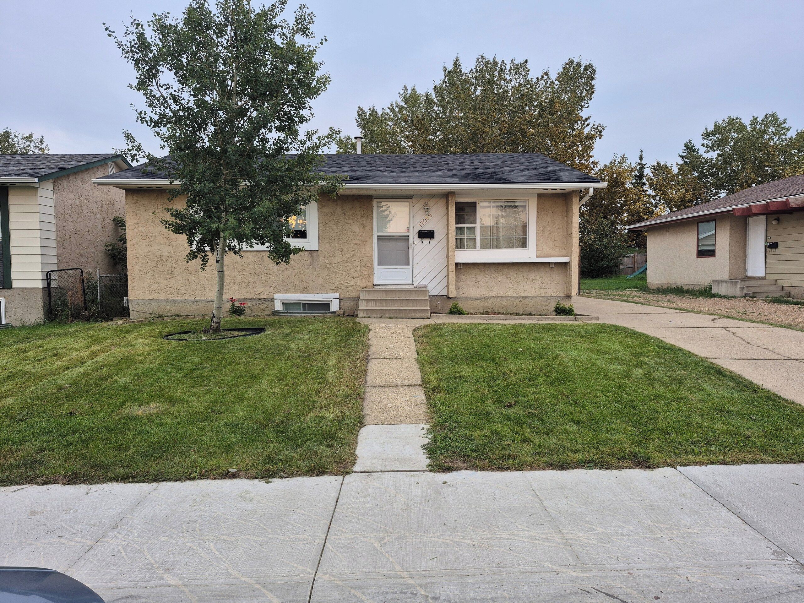 A residential house with a front yard, a driveway, and a mailbox.