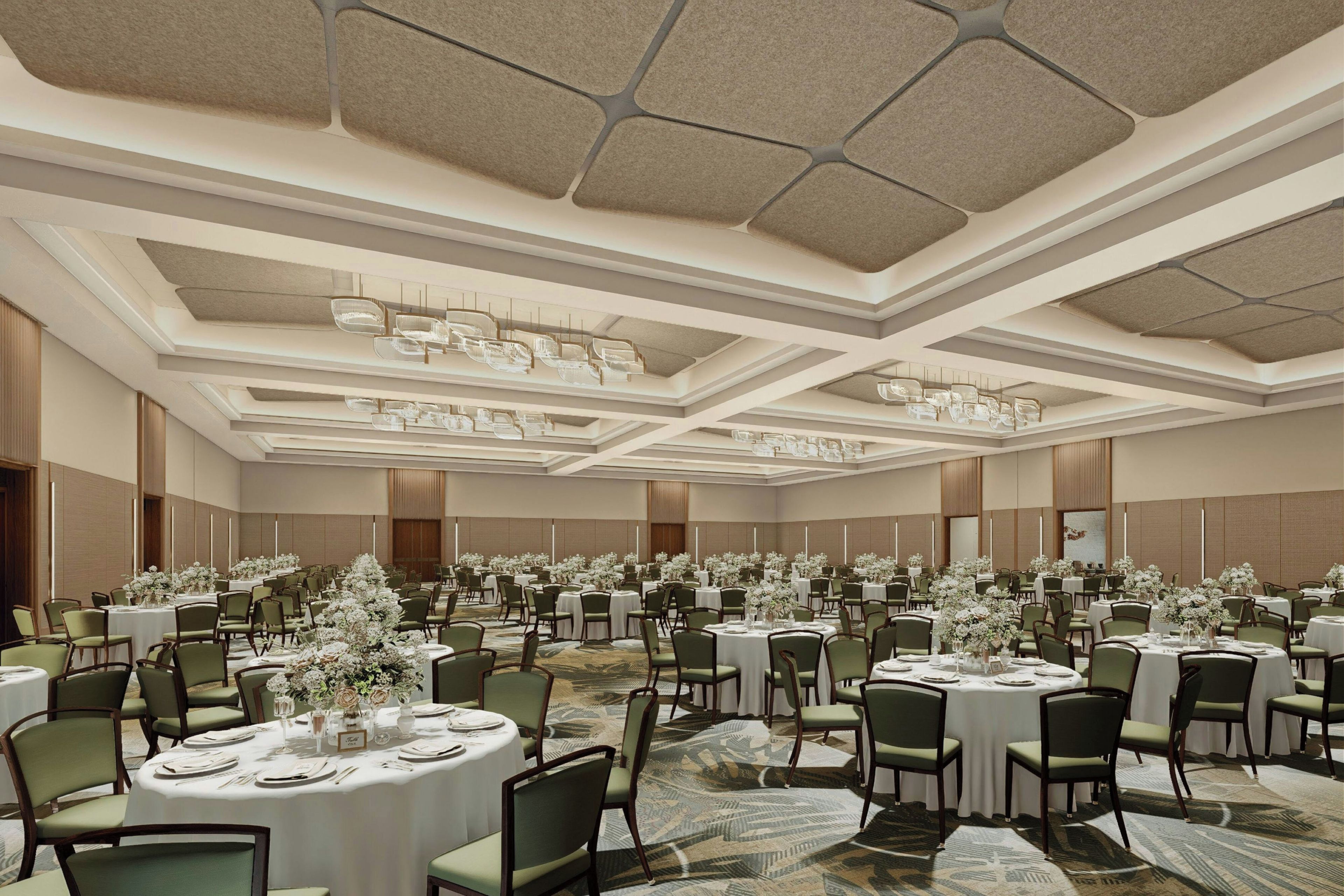 Un gran salón de banquetes con mesas redondas, sillas verdes y centros de mesa florales.