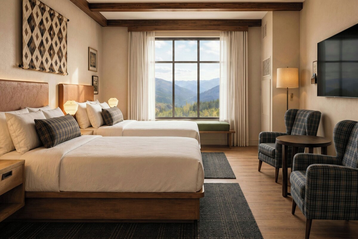 A hotel room with two beds, a sofa, a chair, a TV, and a window with a mountain view.