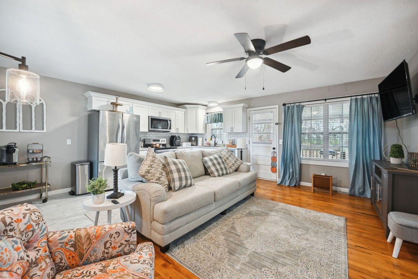 A modern living room with a sofa, a coffee table, and a patterned armchair.