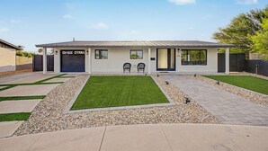 A modern two-story house with a garage, a front lawn with a small garden, and a paved driveway. - Charming 3-bedroom house with AC in lovely Glendale (Glendale)