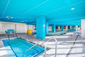 A swimming pool with multiple lanes, a changing room, and a seating area with chairs. - Bay Watch Resort 1519 (North Myrtle Beach)