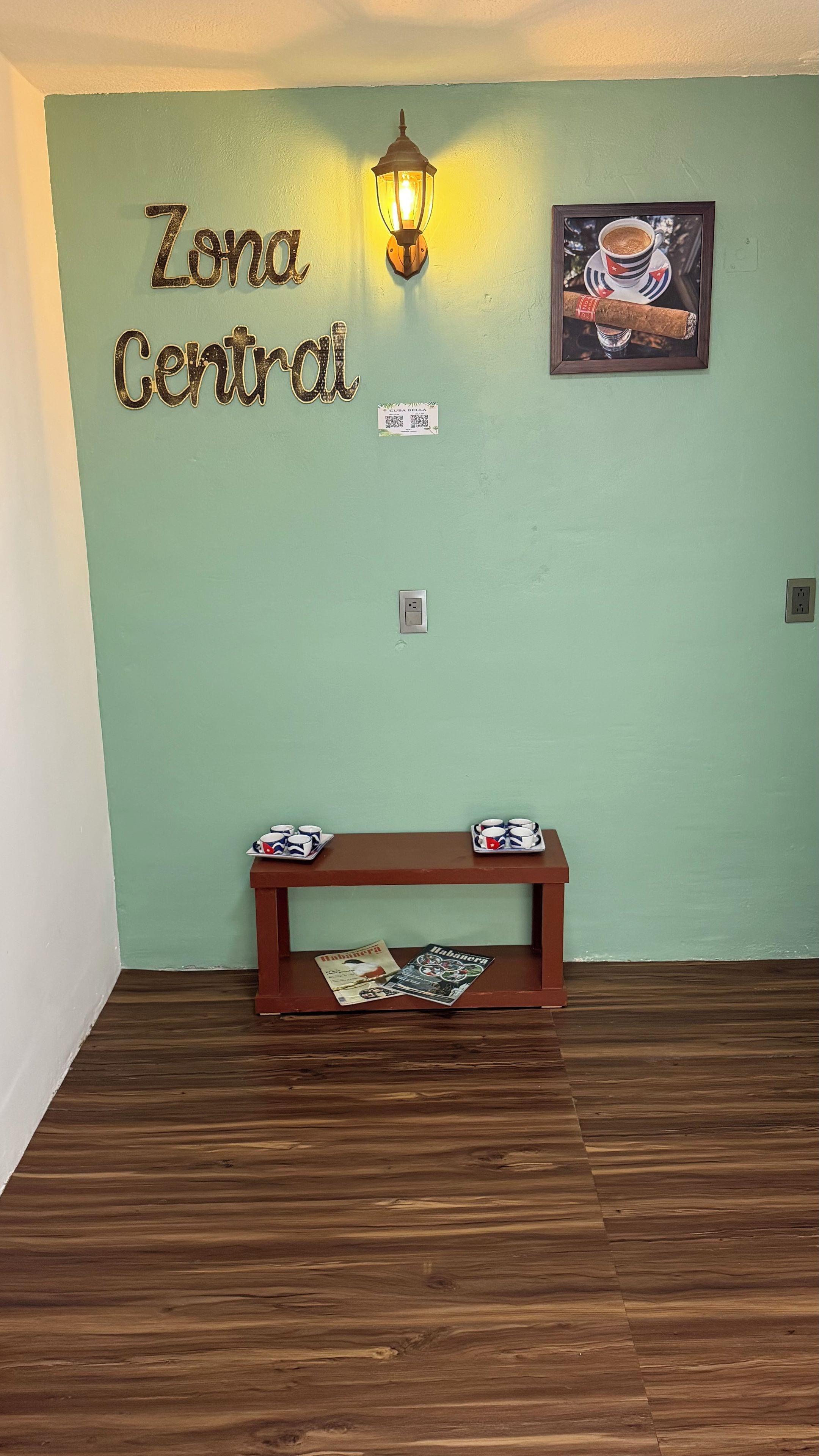 Une pièce avec un banc en bois, un luminaire fixé au mur et un tableau encadré.