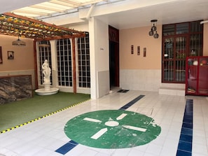 Un hall de hotel con una fuente, una estatua y un diseño circular verde en el suelo.
