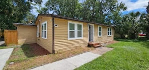A single-story house with a front porch, a small attached garage, and a well-maintained lawn. - Mane Wave's Space Coast Retreat (Cocoa)