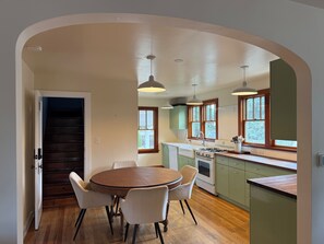 Una cocina con mesa, sillas y estufa.