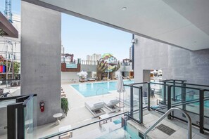 A modern hotel lobby with a pool area, including a glass railing and a view of the cityscape. - Downtown Miami Studio at E11EVEN | 24th Floor (Miami)