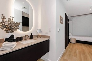 A modern bathroom with a large mirror, a sink, and a vase of dried flowers. - E11EVEN Skyline Studio | 33rd Floor City Views (Miami)