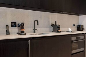 A modern kitchen with a built-in oven, a coffee machine, and a sink. - E11EVEN Skyline Studio | 33rd Floor City Views (Miami)