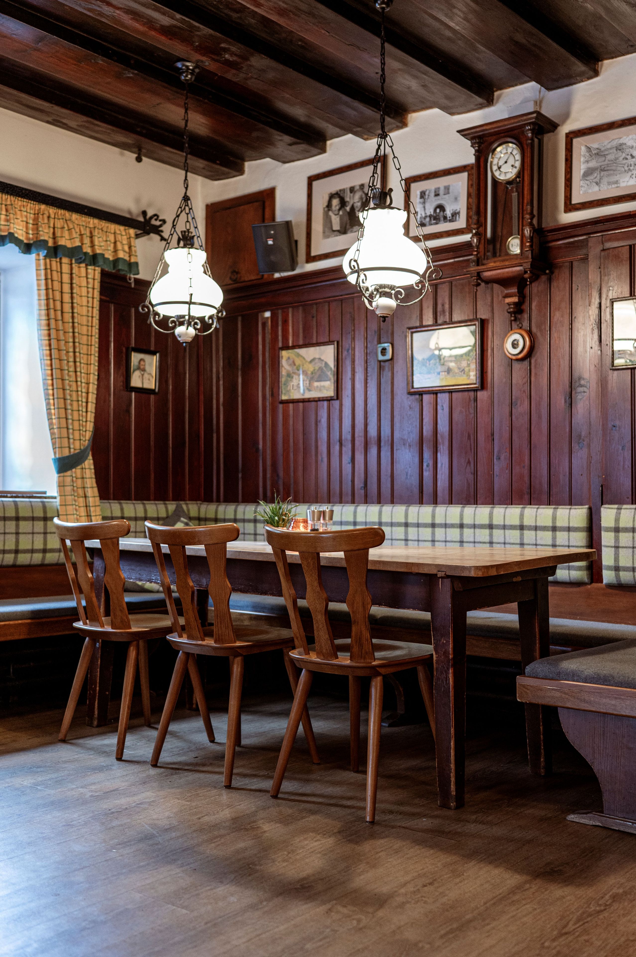Un coin repas en bois avec une table, des chaises et un banc.