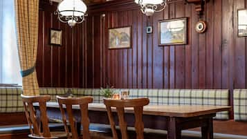 Un coin repas en bois avec une table, des chaises et un banc.