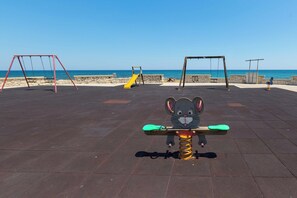 A playground with swings and a seesaw. - Residence La Baia - Bilo PT veranda by BarbarHouse (Casalabate)