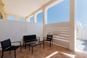 A balcony with two black chairs, a small table, and a potted plant. - Residence La Baia - Bilo PT veranda by BarbarHouse (Casalabate)