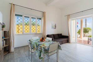 Una habitación con una mesa de comedor, un sofá y vistas al exterior.
