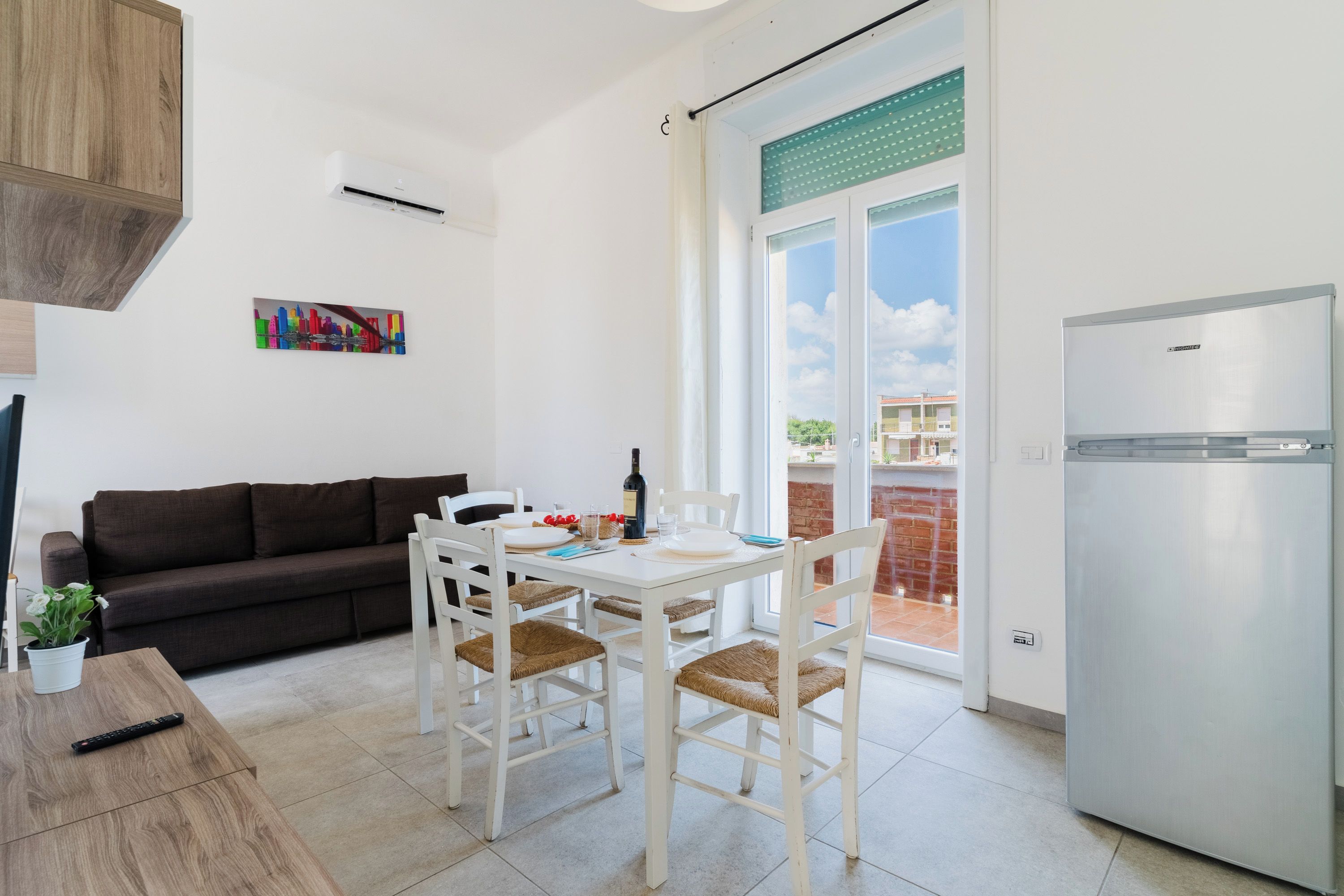 Una cocina moderna con comedor, sofá y refrigerador.