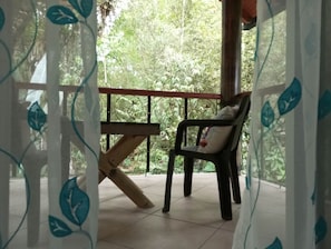 A covered outdoor area with a chair and a wooden bench. - 5 Minutes from Mindo town .Stay Surrounded by Nature, Discover Wildlife & Trails (Quito)
