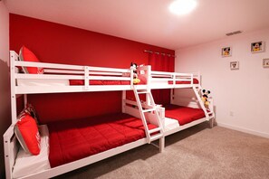 A bunk bed room with red bedding and a Mickey Mouse plush toy on the top bunk. - Themed 5BR Near Disney Pool, Game Room (Kissimmee)