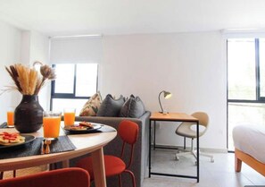 A modern hotel room with a dining area, a sofa, a small desk, and a bed. - Excellent hotel in downtown Guadalajara (Guadalajara)