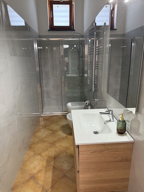 A modern bathroom with a glass-enclosed shower, a white sink, and a wooden vanity. - Residenza Don Alfonso (Somma Vesuviana)