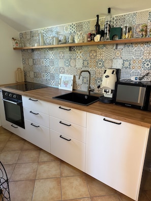 A kitchen with a built-in oven, a dishwasher, a sink, and a coffee maker. - Residenza Don Alfonso (Somma Vesuviana)
