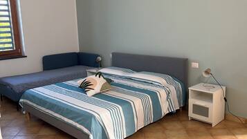 Ein Schlafzimmer mit einem Bett, einem Nachttisch und einem Fenster.