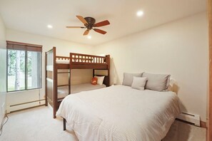 A room with bunk beds, a ceiling fan, a window with blinds, and a bed with pillows. - Charming Condo, Near BC/ Vail Resort, BBQ (Avon)