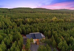 A cabin surrounded by dense forest with a clear view of the surrounding landscape. - Children’s Playset | Hot Tub | Games | Sleeps 16 (Broken Bow)