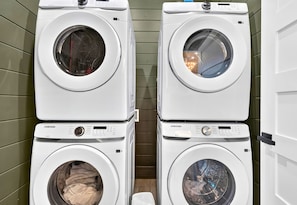 A laundry room with four stacked washing machines. - Children’s Playset | Hot Tub | Games | Sleeps 16 (Broken Bow)