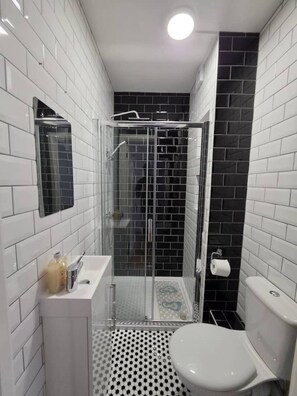A bathroom with a shower enclosure, a toilet, and a sink. - Spacious house in Greater London
5 bedrooms 5 bathrooms (London)